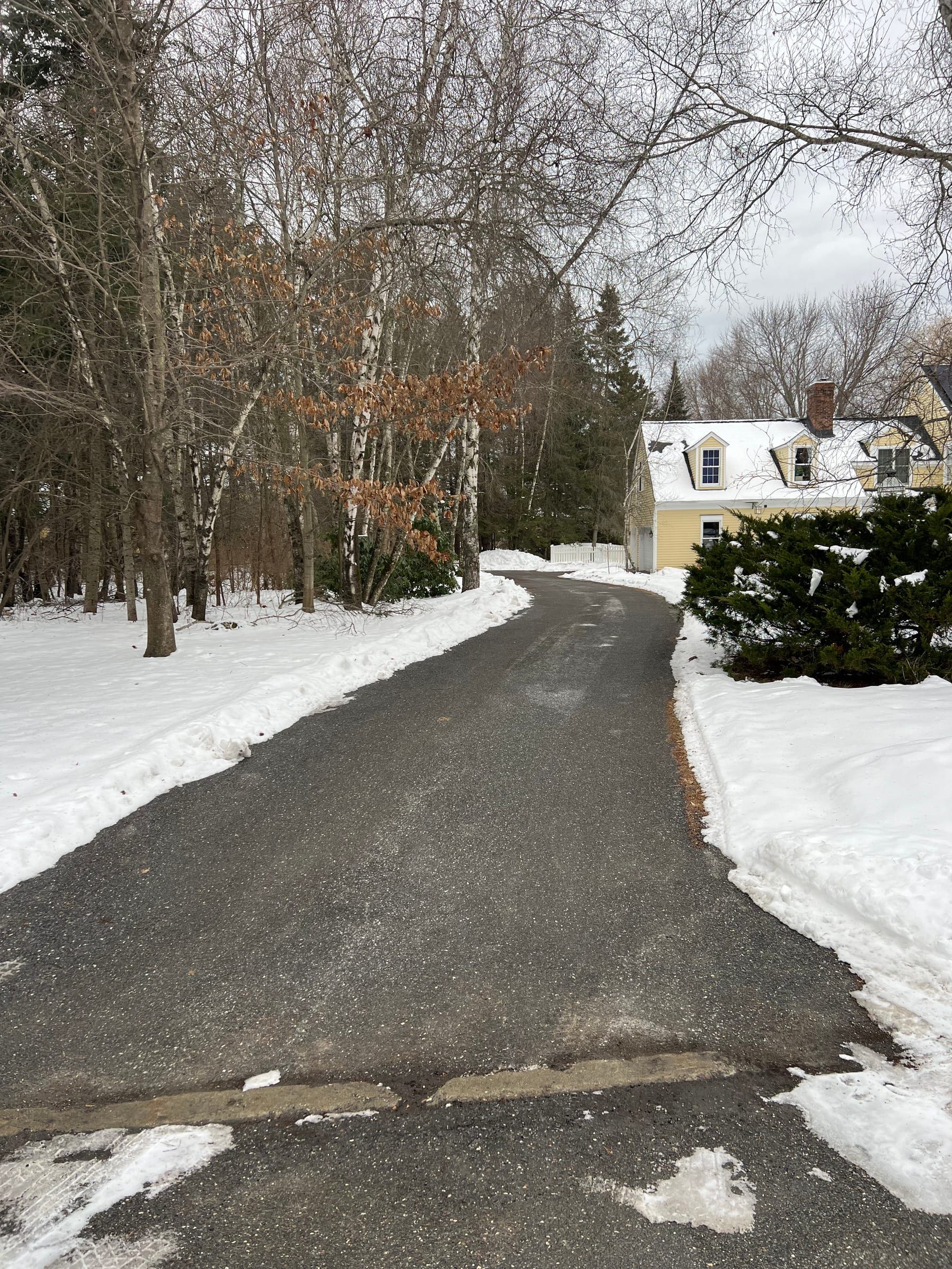 A driveway cleared with snow banked along both sides