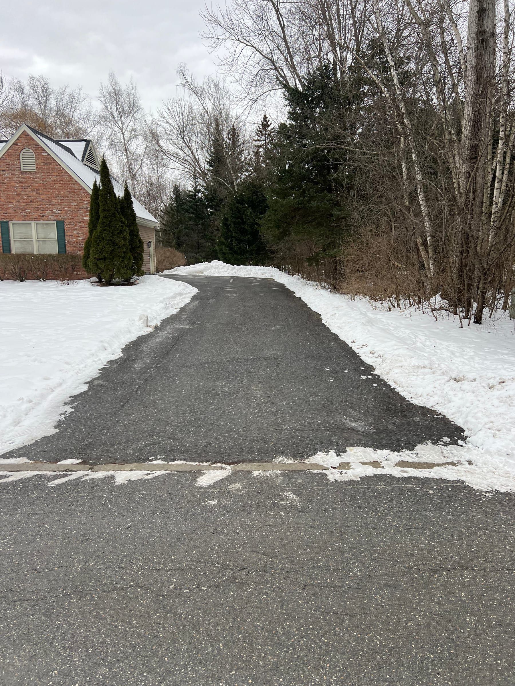 A long driveway cleared down to the pavement after a snowfall