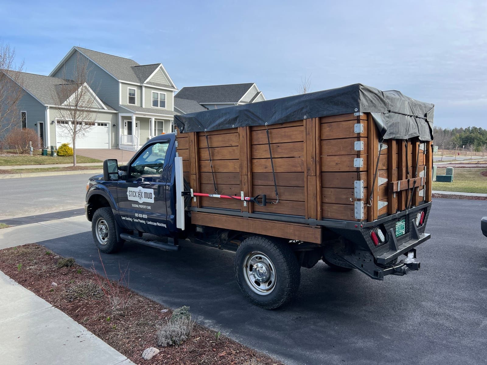 The Stick2Mud dump-body truck parked by fresh mulch beds