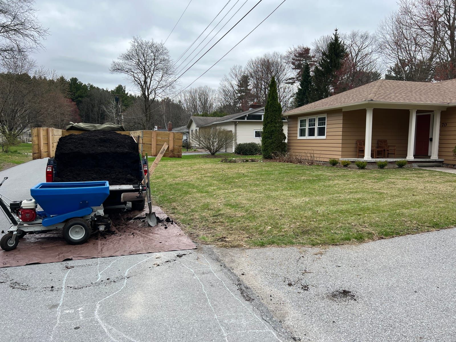 The topdresser unloaded at the curb next to the Stick2Mud truck
